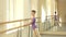 Adorable child studying ballet at dance studio.