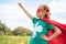 adorable child in superhero costume with outstretched arm