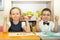 Adorable children boy and girl draws a brush and paints in nursery room. Kid in kindergarten in Montessori preschool class.