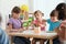 Adorable children drawing together at table. Kindergarten playtime activities