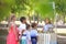 Adorable children waiting in queue for natural lemonade near stand in park