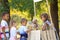 Adorable children waiting in queue for natural lemonade near stand in park