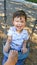 Adorable Chinese and Caucasian Young Boy Having Fun on a Swing