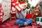 Adorable chinese girl hearing gift sound sitting on floor by christmas tree at home