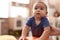 Adorable chinese toddler leaning on stool standing at kindergarten