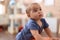 Adorable chinese toddler leaning on stool standing at kindergarten