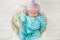 Adorable cute baby girl sleeping in white basket on wooden floor