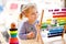 Adorable cute beautiful little toddler girl playing with educational wooden rainbow toy pyramid and counter abacus