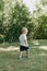 Adorable Cute Little Blond Hair, Blue Eyed Kid Boy in White Tee Shirt Playing and Discovering New Things Outside in Nature