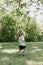 Adorable Cute Little Blond Hair, Blue Eyed Kid Boy in White Tee Shirt Playing and Discovering New Things Outside in Nature