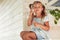 Adorable cute little girl sitting on a porch, making soap bubbles