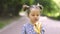 Adorable cute pretty 4-aged Caucasian blond girl eating fresh tasty banana, while walking in the park. The child girl in