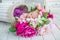 Adorable cute sweet baby girl in white basket with flowers on wooden floor