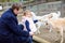 Adorable cute toddler girl and young father feeding little goats and sheeps on a kids farm. Beautiful baby child petting