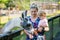 Adorable cute toddler girl and young mother feeding little goats and sheeps on kids farm. Beautiful baby child petting