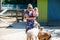 Adorable cute toddler girl and young mother feeding little goats and sheeps on kids farm. Beautiful baby child petting