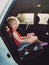 Adorable cute white Caucasian preschool girl child sitting in car seat .