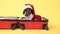 Adorable dachshund dog in Santa costume and hat is sitting in open suitcase, preparing to go on vacation for the