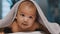 Adorable dark skin baby covered with towel having fun tummy time