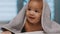 Adorable dark skin baby covered with towel having fun tummy time