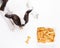 Adorable dog stares with anticipation at a tray of dog treats lying atop a vibrant white background