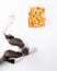 Adorable dog stares with anticipation at a tray of dog treats lying atop a vibrant white background