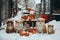 Adorable dogs with snowy fur, sitting outdoors among snow-covered pumpkins and jars.