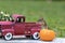 Adorable Eastern Chipmunk poses in Fall Autumn scene with classic red truck and pumpkin