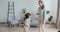 Adorable female babysitter dancing having fun with little boy rejoicing having positive emotion