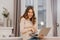 Adorable female freelancer in stylish glasses posing with pleasure during work with laptop. Indoor photo of blissful