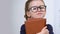 Adorable female pupil in eyeglasses holding books, need of knowledge, genius