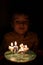Adorable five year old kid celebrating his birthday and blowing candles on homemade baked cake, indoor. Birthday party