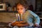 Adorable four year old boy celebrating his birthday and blowing