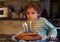 Adorable four year old boy celebrating his birthday and blowing