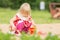 Adorable girl in dress play on sandbox