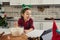 Adorable girl, little child vlogger recording video while standing by table and cooking Christmas pastry, mixing ingredients in