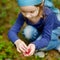 Adorable girl picking foxberries in the forest