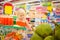 Adorable girl in shopping cart looks at giant jack fruits on box