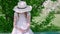 Adorable girl sitting on bench and using smartphone in park