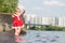 Adorable girl stay in water on pier ladder