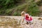Adorable girl throw stone to river stream in park