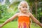 Adorable girl with two tropical flowers behind ears in park