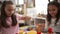 Adorable girls playing with construction blocks sitting on table at kindergarten