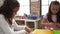 Adorable girls playing with construction blocks sitting on table at kindergarten