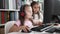 Adorable girls students using computer and headphones studying at classroom