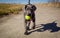 An adorable Great Dane puppy walks towards viewer carrying a tennis ball