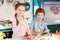 adorable happy children in aprons smiling at camera while cooking together