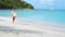 Adorable happy little girl on white beach at sunset.