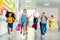 adorable happy schoolchildren running by school corridor together with teacher