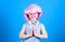 Adorable headset user with praying hands. Small child wearing adjustable white headset and pink hair wig. Little girl